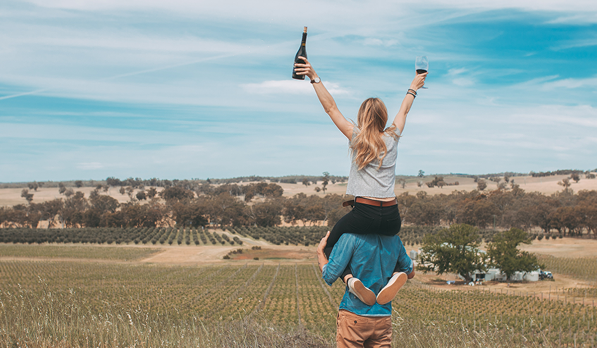 Man giving a woman a piggyback in vineyard